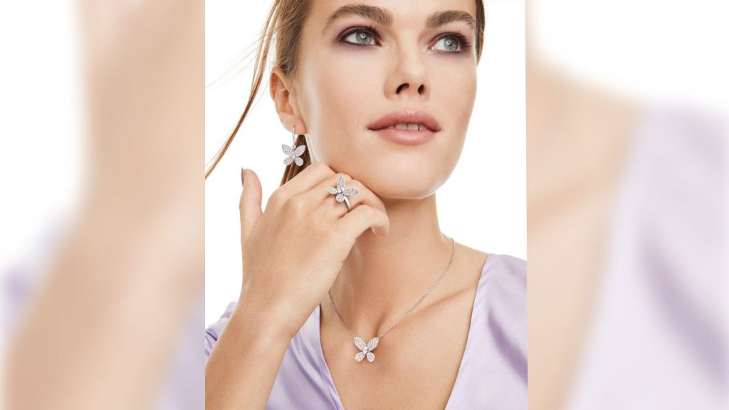 Women wearing butterflies white diamond earrings, ring and collar.
