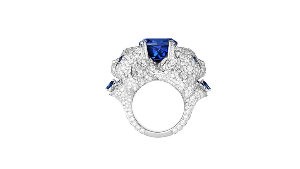 Blue diamond centered between two cats heads with white diamonds on a ring